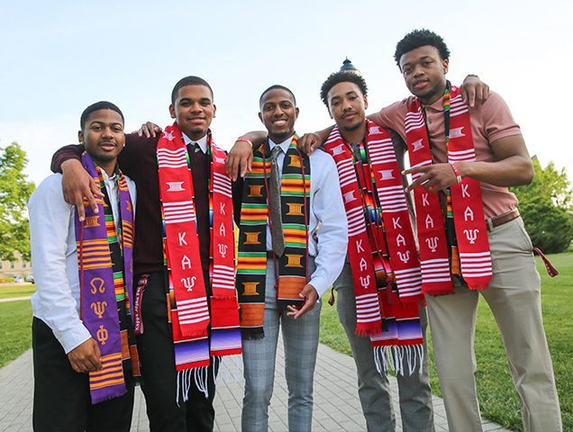 Five Xavier students wearing fraternity graduation stoles