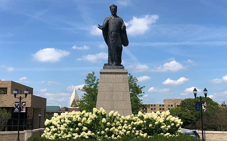 Statue of St. Francis Xavier surrounded by blooming hydrangeas