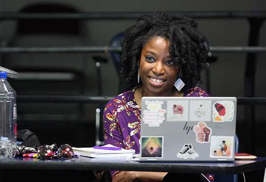 A student sitting at a desk with an open laptop.