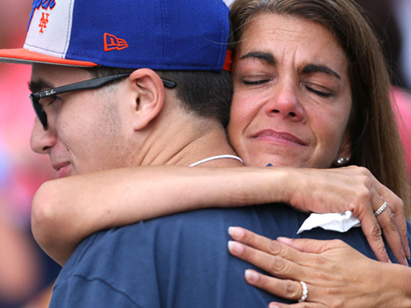 A close up photo of a mother hugging her son.