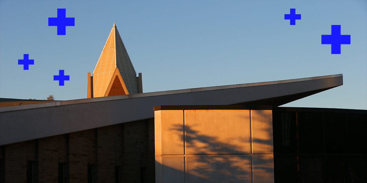 Three students walking outside of the Health United Building on a fall day