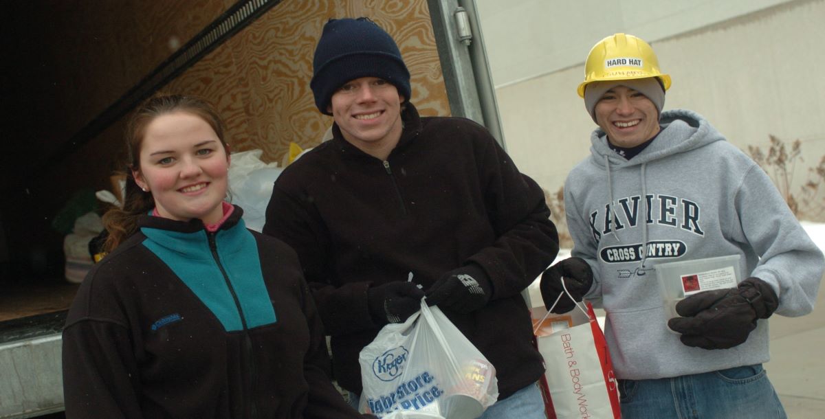 Students holding bags of donated food