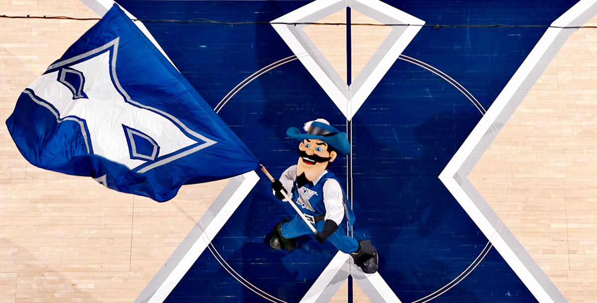 D'Artagnan mascot waving the Xavier flag over the Cintas Center court