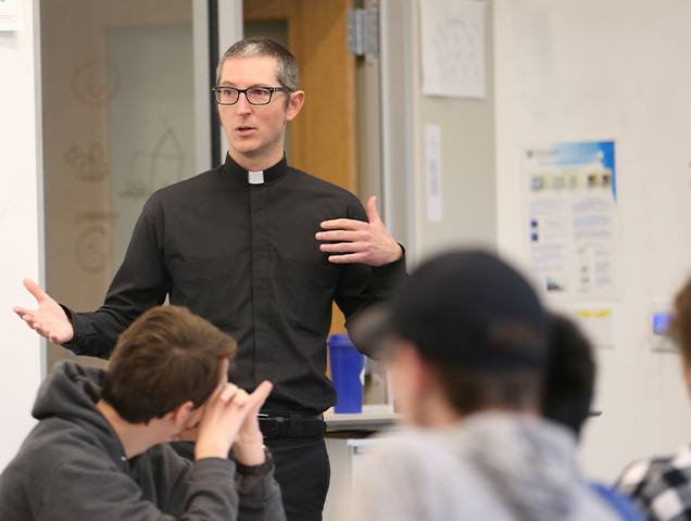 Students in the biophysics major learning from a Jesuit professor in a classroom