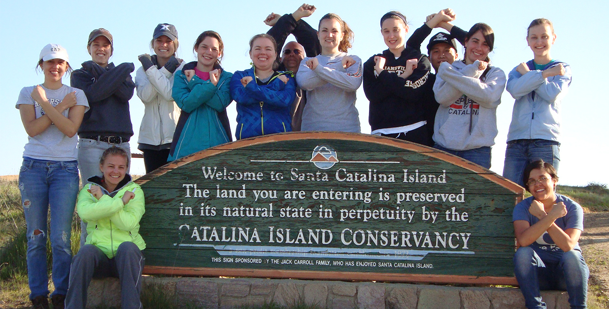 A group of Xavier students beside a park sign on Santa Catalina Island in California