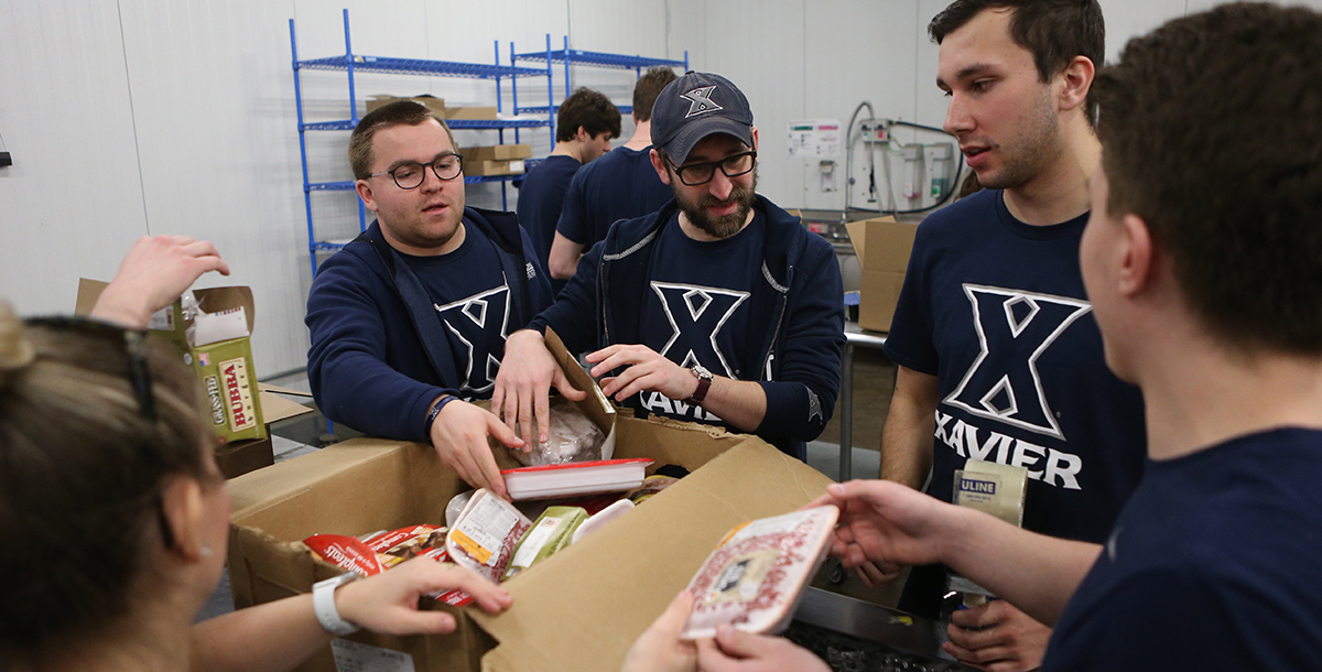Xavier students packing food during an Alternative Breaks trip