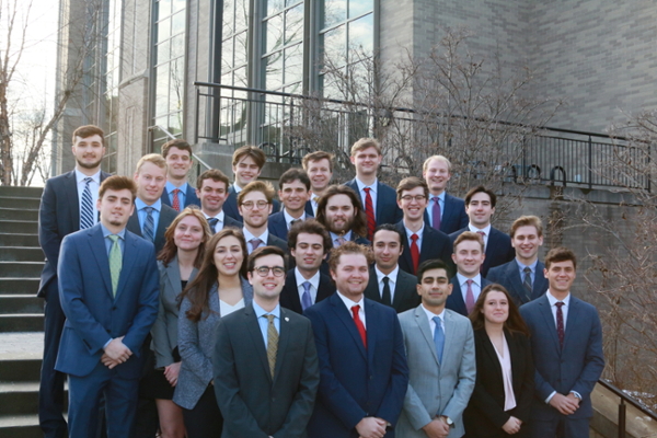 Group of Xavier students who run the The D'Artagnan Capital Fund. They are standing in a group on the Ignatian Steps on Xavier's campus. Everyone is wearing business professional attire.