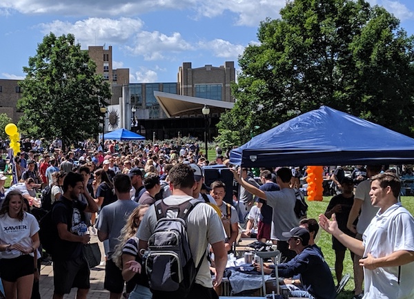 Hundreds of Xavier students fill the academic yard on campus for Club Day. Multiple booths are set up for students to explore clubs.