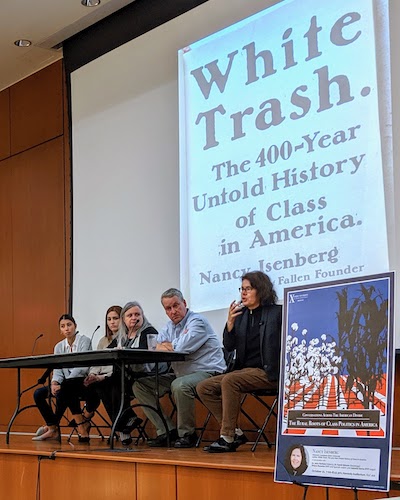 A panel of five adults sit in front of a projection screen. The text on the projection screen reads: 'White Trash. The 400-Year Untold History of Class in America. Nancy Isenberg. 