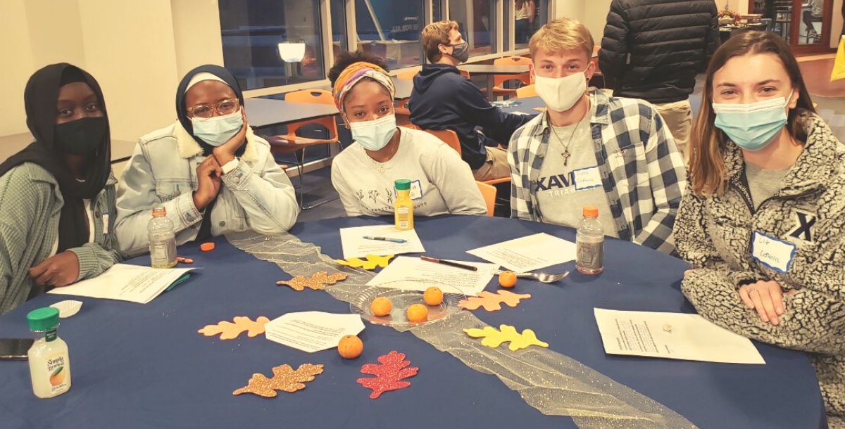 Five Xavier students gathered at a table