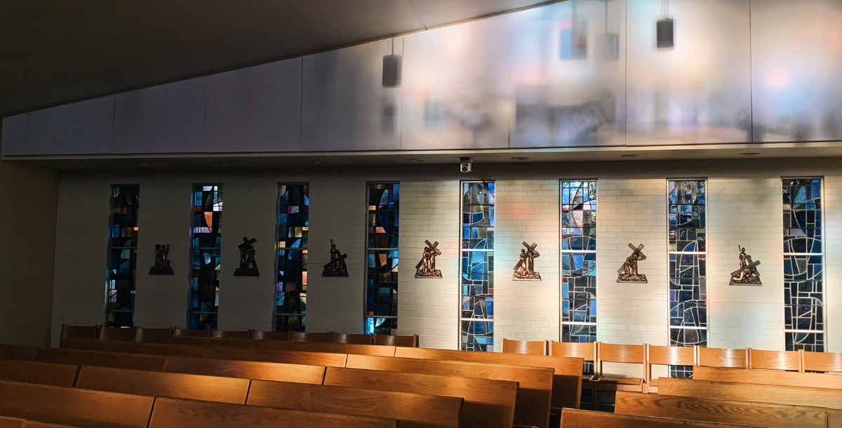 Filtered light in the empty chapel highlighting the Stations of the Cross