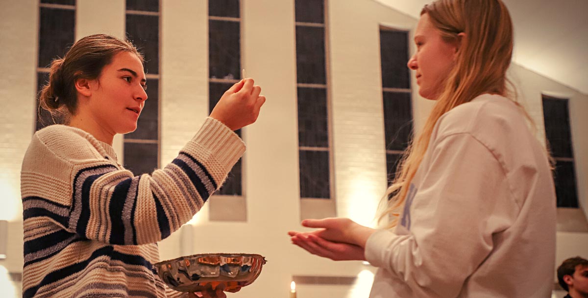 Student distributing the Eucharist at Mass