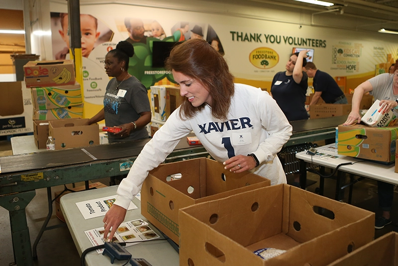 Xavier employee organizing cans in a food pantry