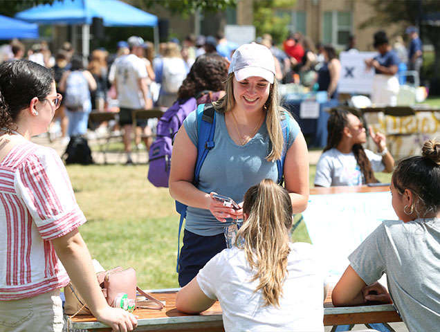 Students talking at a club day table