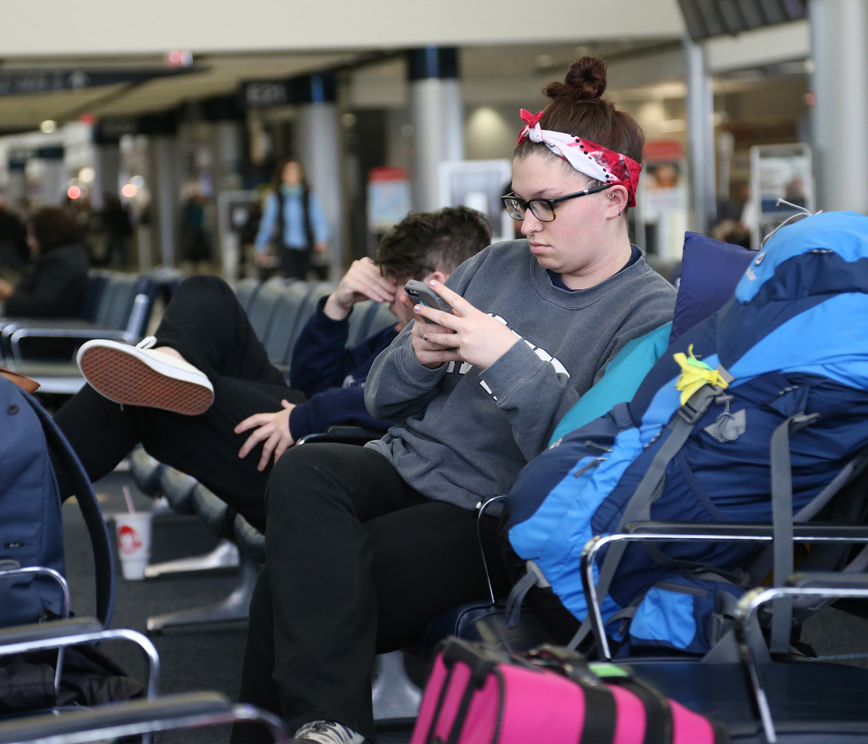 Xavier student sitting at a terminal at the Covington airport