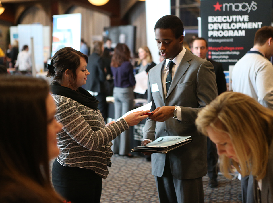 A Xavier student conversing with a business representative at a career fair