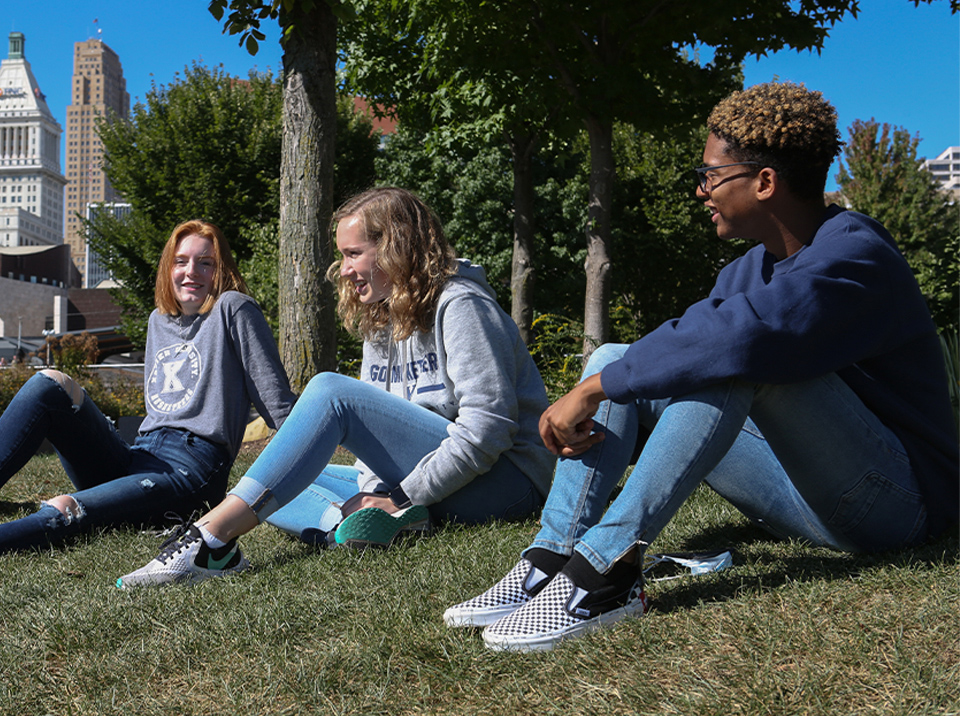 Three Xavier students sitting outside together at a park in downtown, Cincinnati