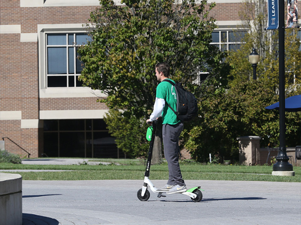 Xavier student on a scooter on campus