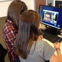 Two Xavier students speak via video conference with a student at another Jesuit school in Spanish