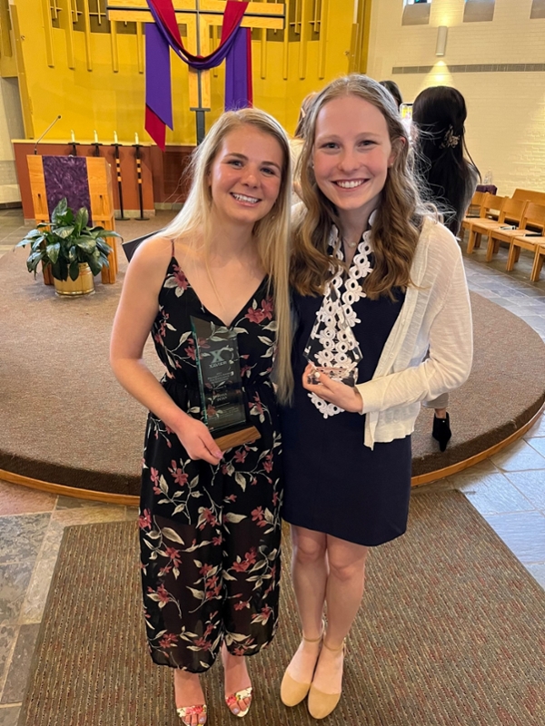 Two Community Engaged Fellows inside Bellarmine Chapel with their awards