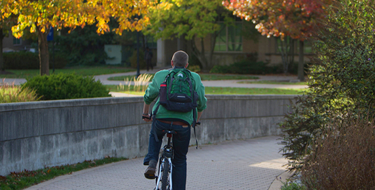 Person riding on bike through campus