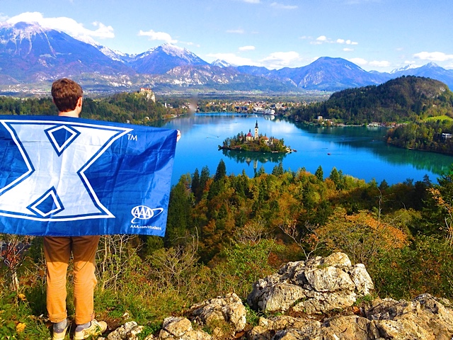 Photo of Student with XU Banner behind his back on a Study Abroad Trip