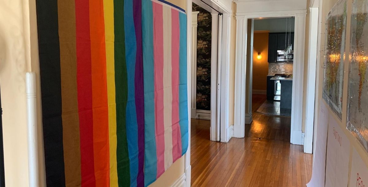 A pride flag hanging on a wall in someone's home. 