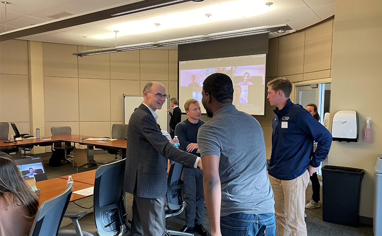 Two people shaking hands during a economics board member meeting