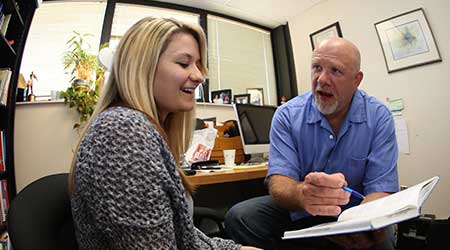 Graduate student meeting with a professor during office hours