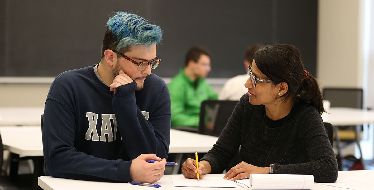 Student working with a professor at a desk