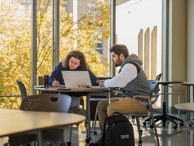 Two students in the exploratory major reviewing information in a notebook 