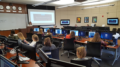 Young women in business, listening to a speaker in the Fifth Third Trading Center