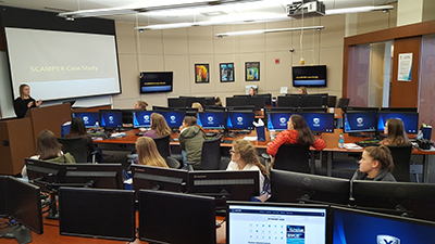 Young women in business, listening to a speaker in the Fifth Third Trading Center