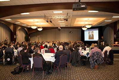 Susan McCormick speaking at the McCormick investiment symposium, full room view.