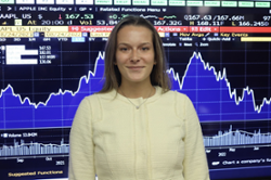 Photo of Emma Harris in front of a stock graph