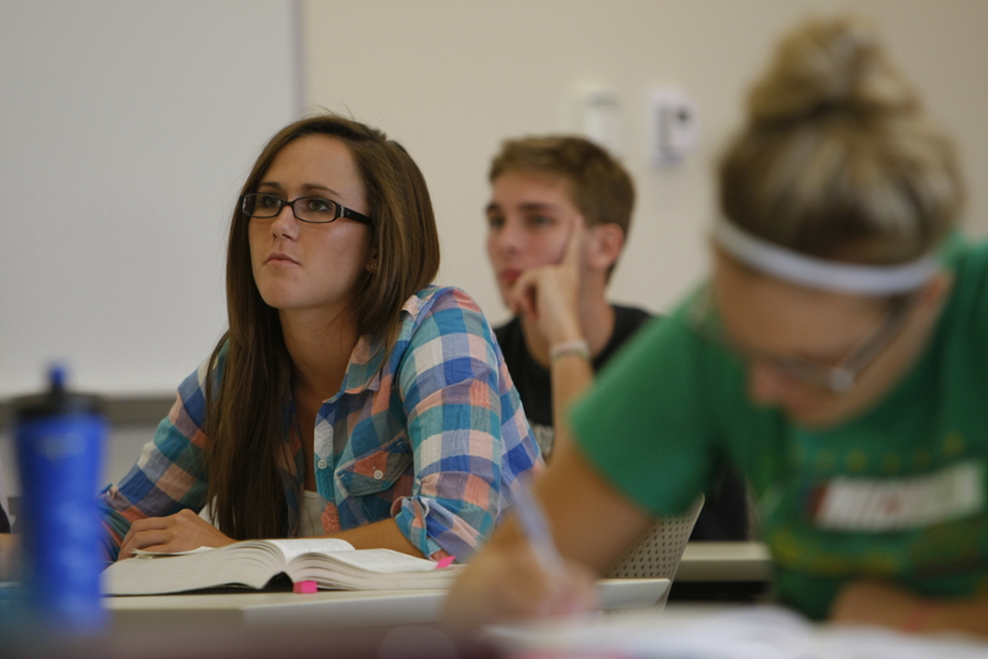 Students sitting at a desk listening to a lecture