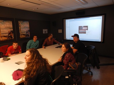 Photo of Students inside a Conference Room with a Projector on in the background