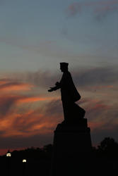 The silhouette of the St. Francis Xavier statue on Xavier's campus at sunset.