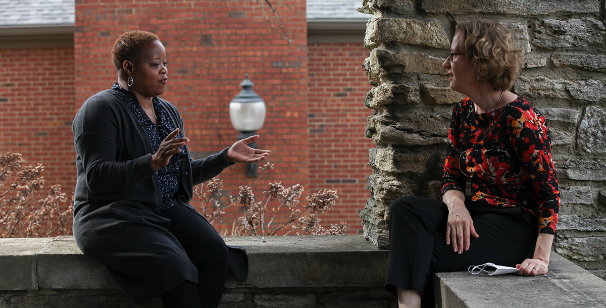 Two Xavier employees talking with each other outdoors