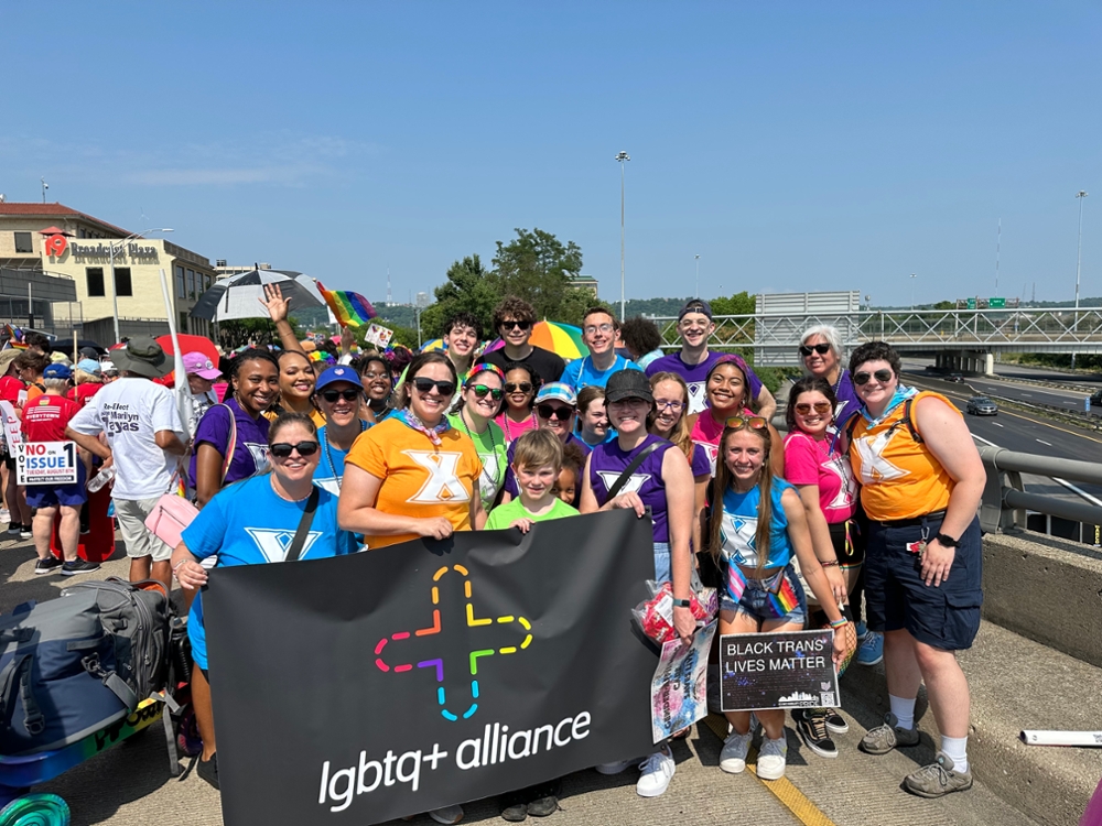 group picture of Xavier Students holding LGBTQ+ Alliance flag