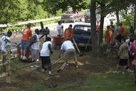 A group of volunteers working on an outdoor landscaping project together on a sunny summer day