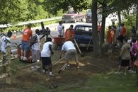 A group of volunteers working on an outdoor landscaping project together on a sunny summer day