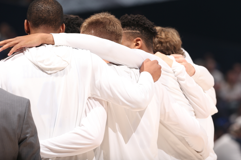 Xavier basketball team players huddling