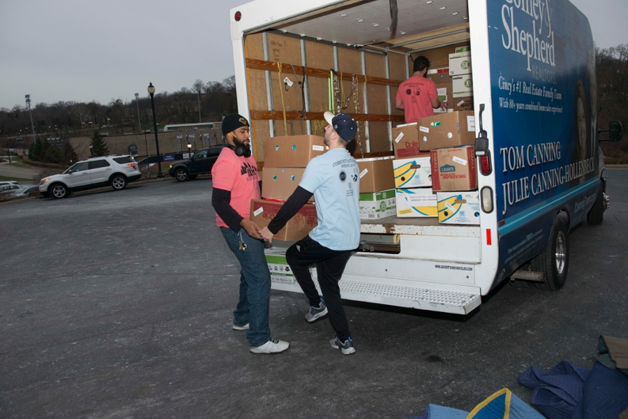 People lifting heavy boxes out of a truck