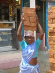 Person carrying bricks on their head