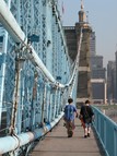 Two people walking across a bridge