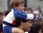 A child sits on their father's shoulders