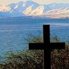 A cross in the foreground and mountains in the background