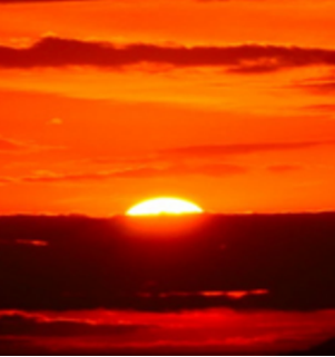 The sun setting on a beach