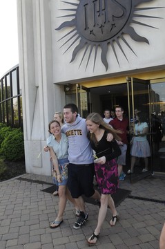 Three people walking out of a church